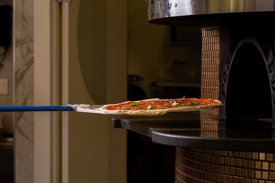 Pizza being placed into an oven