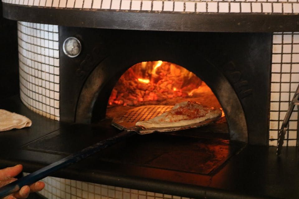 Pizza baking in a wood-fired oven