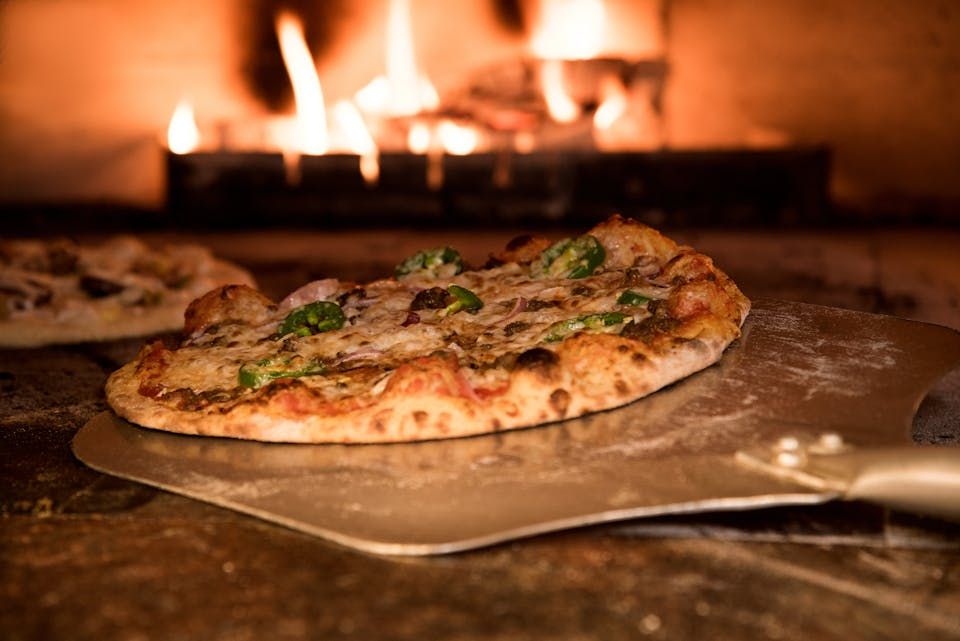 Pizza on a peel near a hot oven